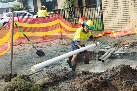 A Council staff member replacing piping to repair a broken water main in Tweed Heads